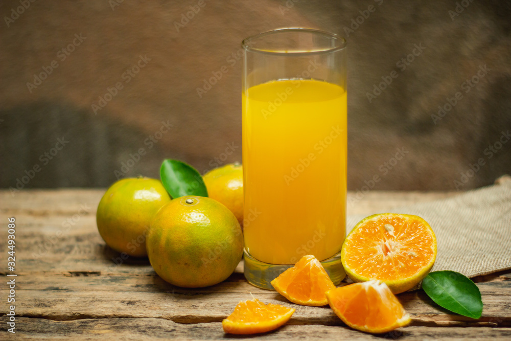 A glass of orange juice and citrus fruits on a wooden table A glass of orange juice and citrus fruits on a wooden table