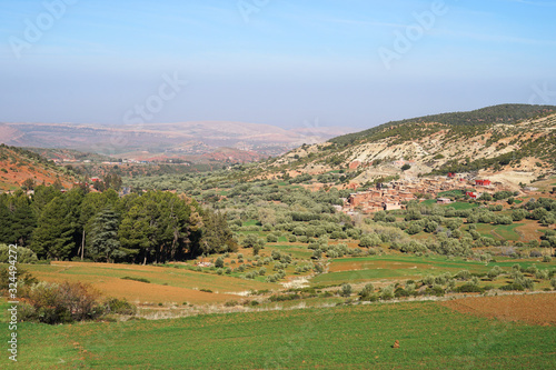 Small Berber village and agriculture fields in panoramic view in Atlas Mountains, Morocco