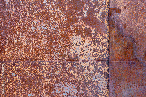 two sheets of rusty metal welded together lie on each other.