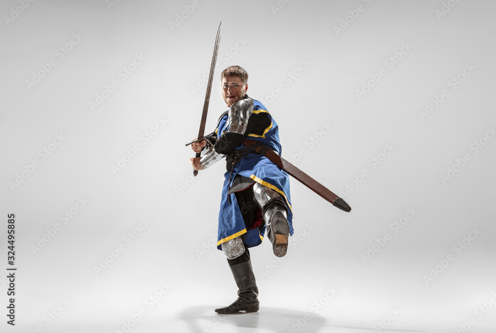 Brave armored knight with professional weapon fighting isolated on white studio background. Historical reconstruction of native fight of warriors. Concept of history, hobby, antique military art. Brave armored knight with professional weapon fighting isolated on white studio background. Historical reconstruction of native fight of warriors. Concept of history, hobby, antique military art.