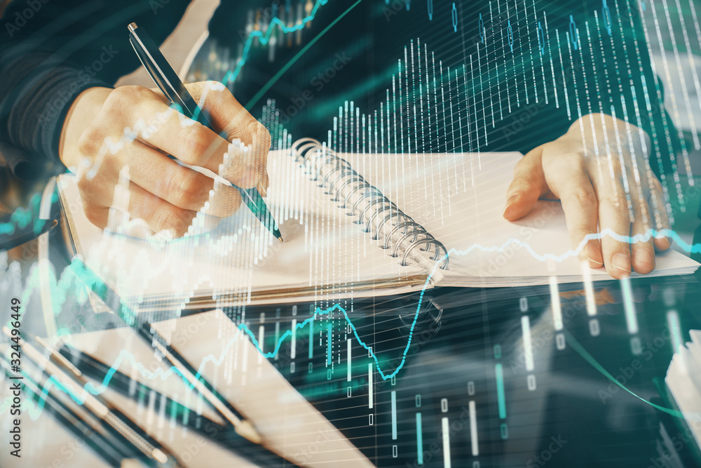Forex chart hologram on hand taking notes background. Concept of analysis. Multi exposure Forex chart hologram on hand taking notes background. Concept of analysis. Multi exposure