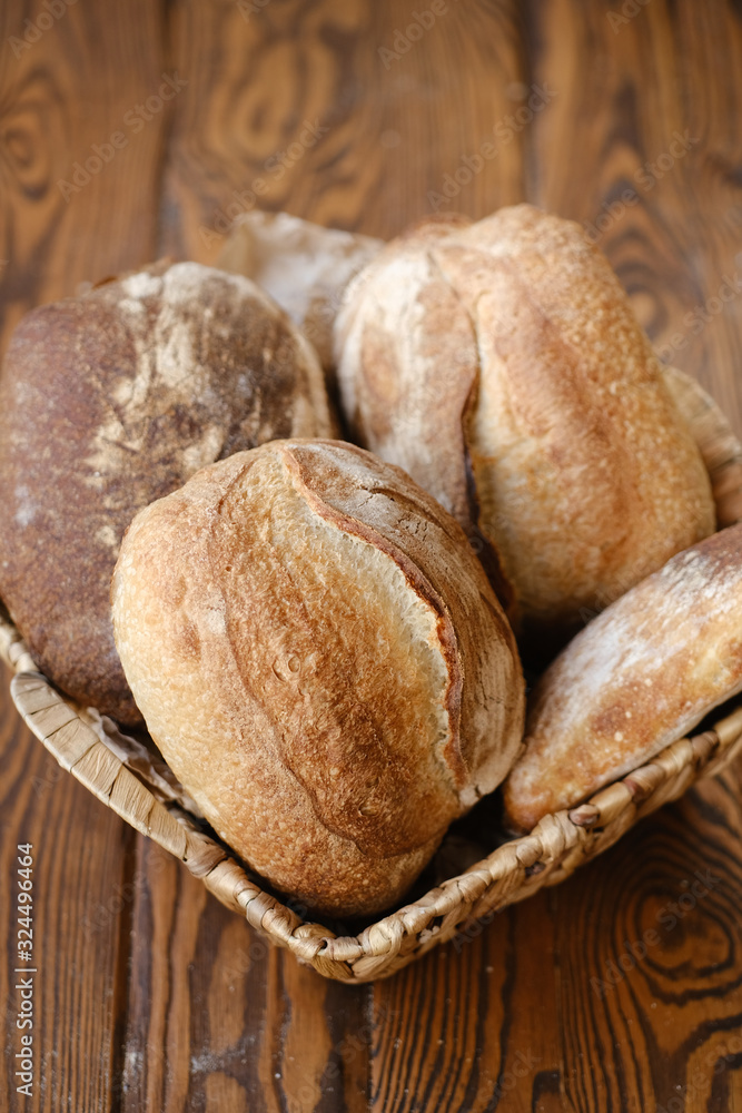 Assortment of baked bread on wooden table background. Bread background, top view of white, black and rye loaves. Healthy food. 