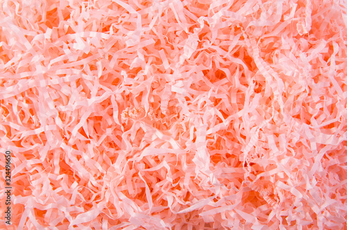 Fotografia Coral color shredded paper gift box filler background.