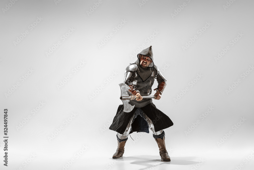 Brave armored knight with professional weapon fighting isolated on white studio background. Historical reconstruction of native fight of warriors. Concept of history, hobby, antique military art. Brave armored knight with professional weapon fighting isolated on white studio background. Historical reconstruction of native fight of warriors. Concept of history, hobby, antique military art.