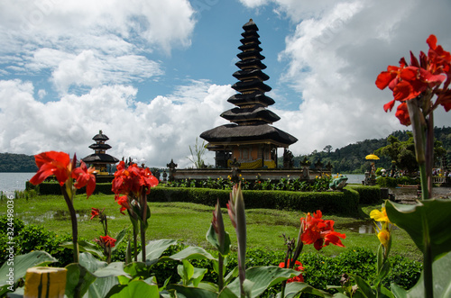 Templo Pura Ulun en el lago con cielo azul y flores de colores