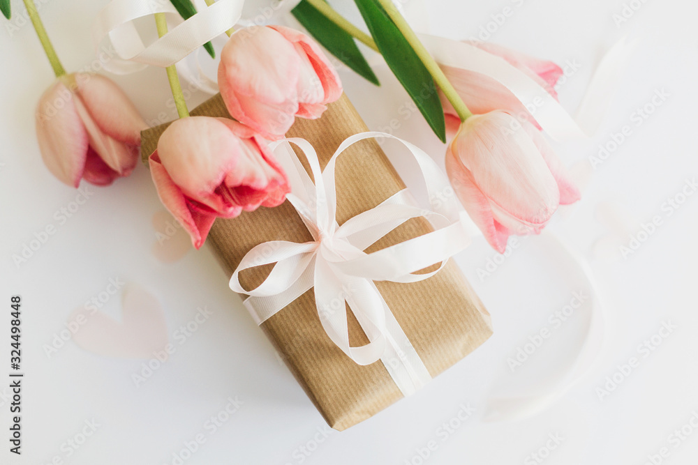 Happy womens day. Pink tulips flat lay with ribbon and gift box on white background. Stylish soft image of spring flowers. Greeting card mockup. Happy Mothers day. Hello spring Happy womens day. Pink tulips flat lay with ribbon and gift box on white background. Stylish soft image of spring flowers. Greeting card mockup. Happy Mothers day. Hello spring
