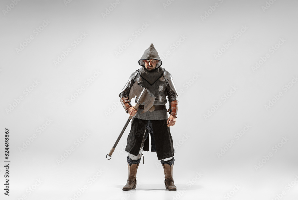 Brave armored knight with professional weapon fighting isolated on white studio background. Historical reconstruction of native fight of warriors. Concept of history, hobby, antique military art.