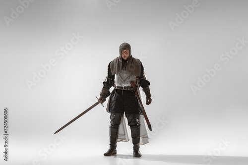 Fototapeta Brave armored knight with professional weapon fighting isolated on white studio background