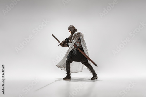 Fotografia Brave armored knight with professional weapon fighting isolated on white studio background