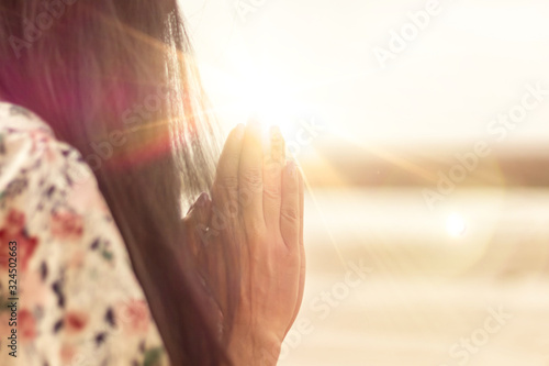 A woman praying hand for blessings When the sun goes down Hope for a happy life