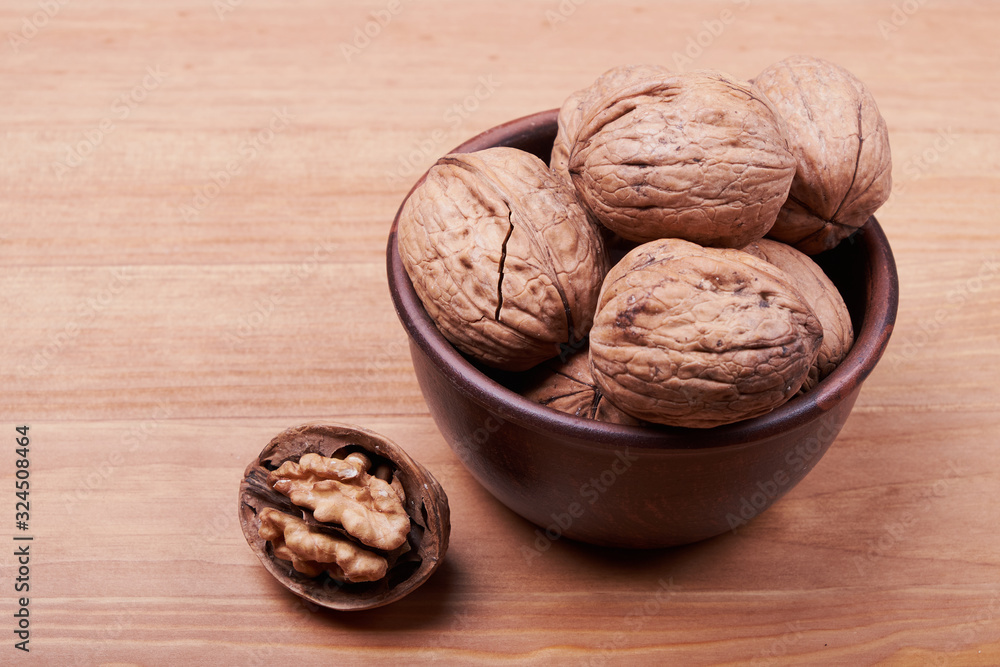 Walnut kernels and whole walnuts on rustic old wooden table Walnut kernels and whole walnuts on rustic old wooden table