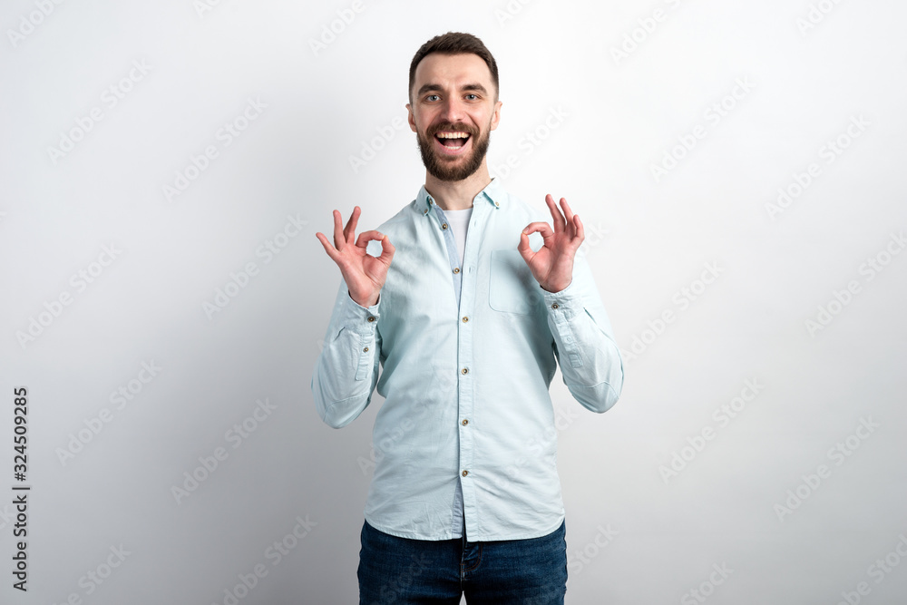 Portrait of cheerful man showing gesture ok from his both hands and looking at the camera Portrait of cheerful man showing gesture ok from his both hands and looking at the camera
