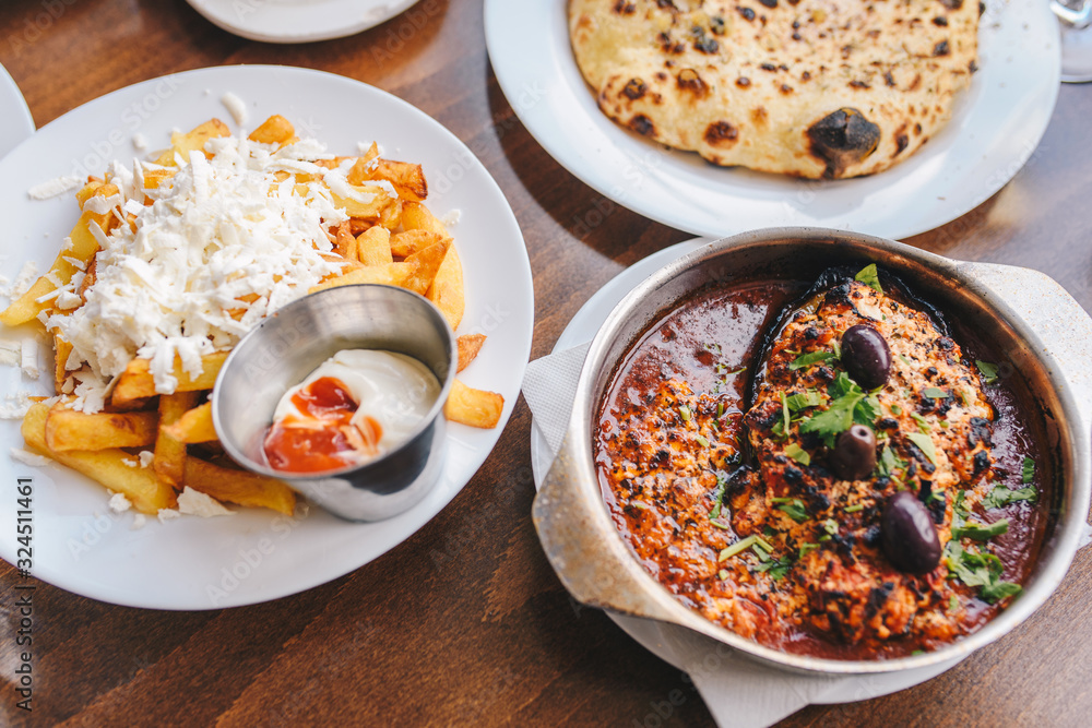 Balkan food - roasted eggplant in tomato sauce and cheese and french fries with cheese. Balkan restaurant. Balkan food - roasted eggplant in tomato sauce and cheese and french fries with cheese. Balkan restaurant.