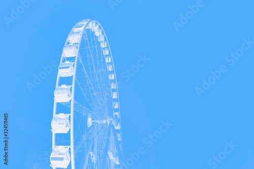 Fototapeta Naklejka Na Ścianę i Meble -  White ferris wheel on a blue color background. Minimal concept. Copy space
