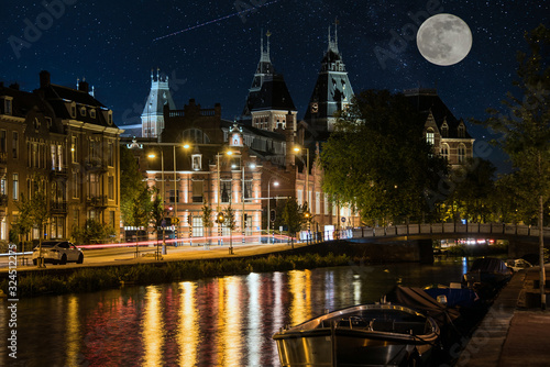Moon over Amsterdam at Night with a Canal and Reflections