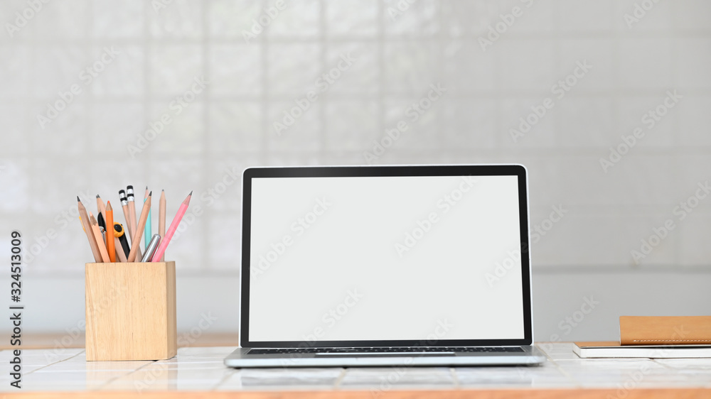 Laptop with white blank screen putting on modern white ceramic tile ...