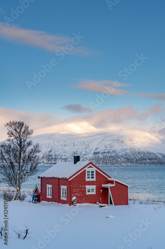 landscape with scandinavian red boat houses at the shore of the grotsundet, north of Tromso, northern Norway