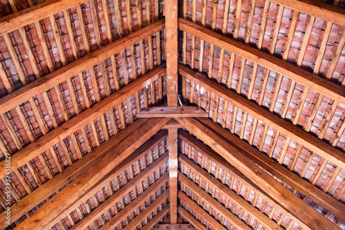 Wooden roof ridge in a old attic with view of the roof shingles