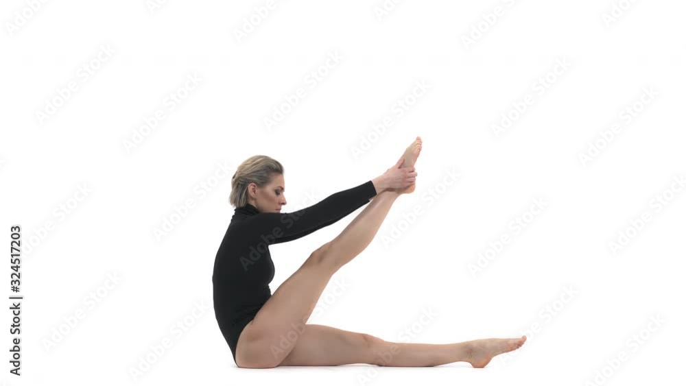 Millennial professional female athlete performs complex gymnastic exercise. Stretching exercises demonstration Millennial professional female athlete performs complex gymnastic exercise. Stretching exercises demonstration