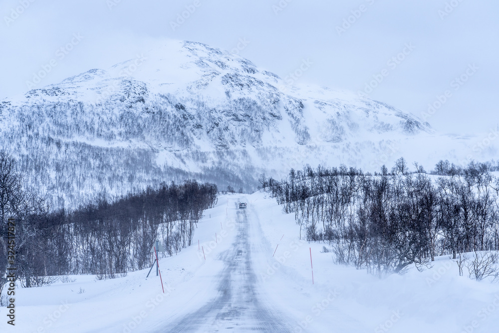 Obraz premium icy and snow covered road during a blizzard in the highland Tundra of northern Norway