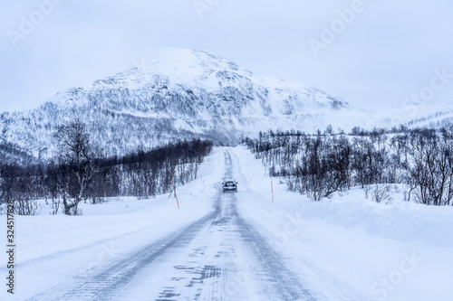icy and snow covered road during a blizzard in the highland Tundra of northern Norway