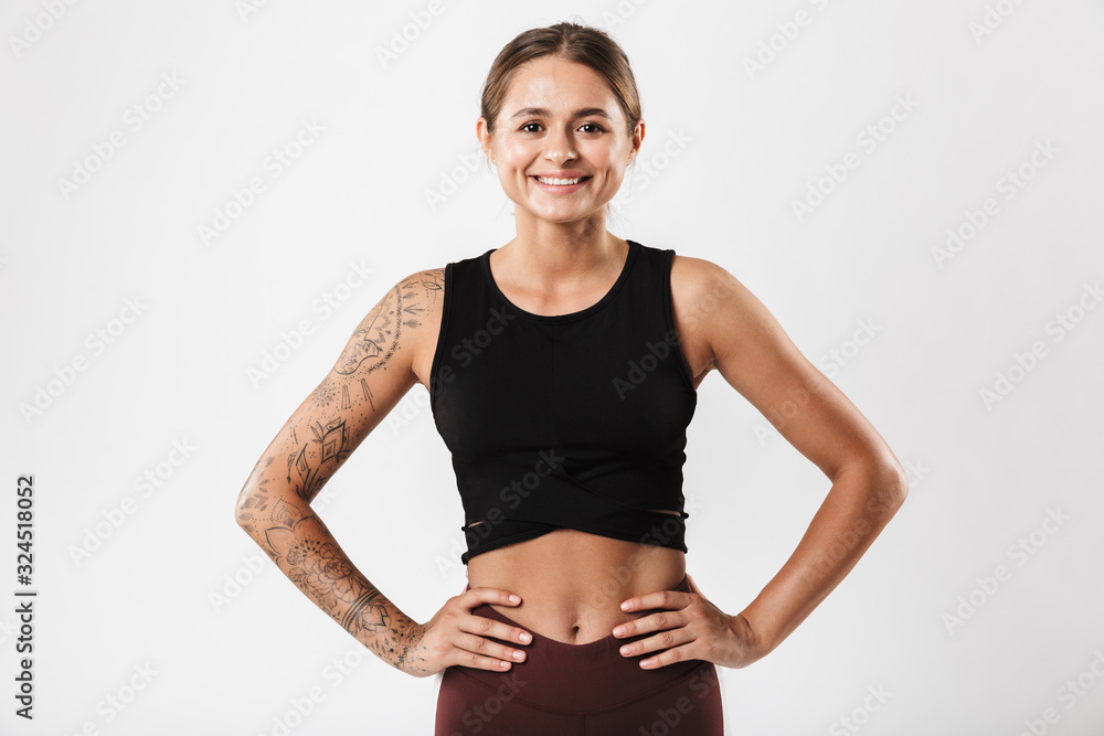 Image of joyful woman smiling and standing with arms on waist Image of joyful woman smiling and standing with arms on waist