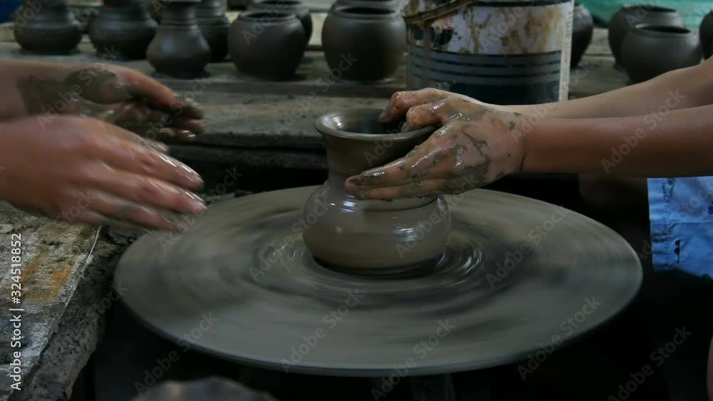 Potters hands are creating a jar or vase of earthenware on potters wheel Potters hands are creating a jar or vase of earthenware on potters wheel