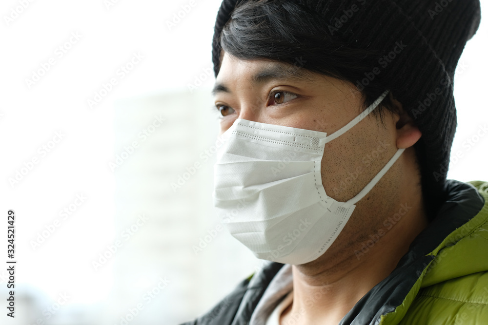 屋外で感染症予防の為に衛生マスクをしているニット帽をかぶった日本人男性の顔アップ横顔 Stock Photo Adobe Stock
