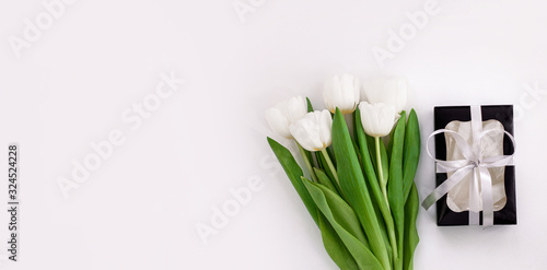 Spring website header template. White tulip black gift box with silver ribbon on light background flat lay. Text place 8 March Happy Mothers Day Sales.Bouquet greeting card. Copy space banner top view