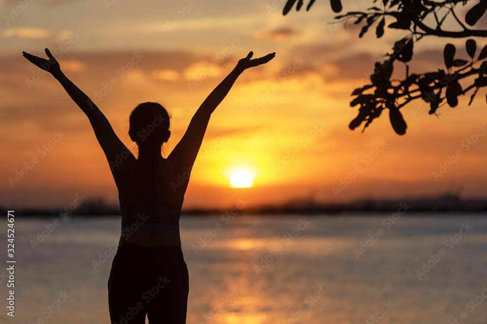 Silhouette woman raise hands feeling relax and freedom. People running and workout in sunset background. Lifestyle and Healthy Concept.
