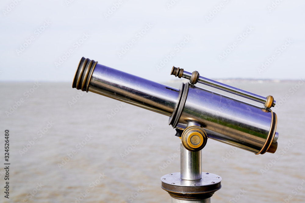 Touristic old seaside pay to view silver paid telescope in sea coast horizon