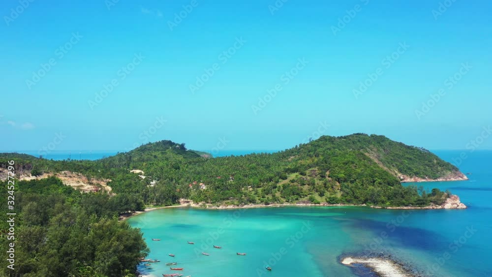 Beautiful green hills of tropical island with rocky coastline and white beaches washed by calm turquoise lagoon in Thailand Beautiful green hills of tropical island with rocky coastline and white beaches washed by calm turquoise lagoon in Thailand