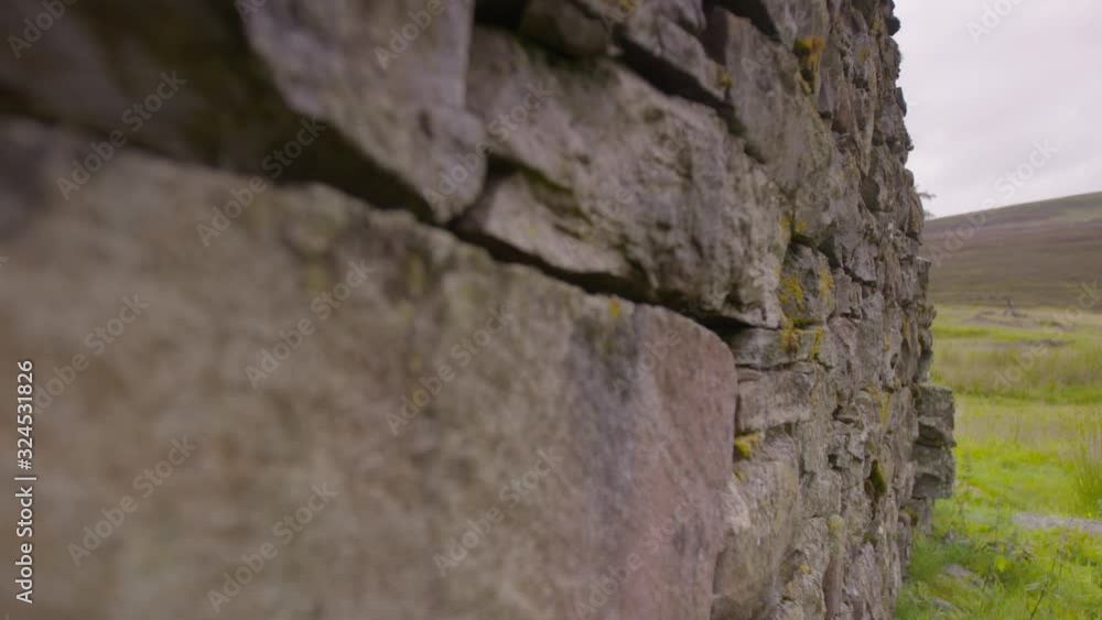 Extreme close-up low angle tracking focus still shot of stone ruins of a traditional Scottish cottage, Braemar highlands, Scotland, UK Extreme close-up low angle tracking focus still shot of stone ruins of a traditional Scottish cottage, Braemar highlands, Scotland, UK
