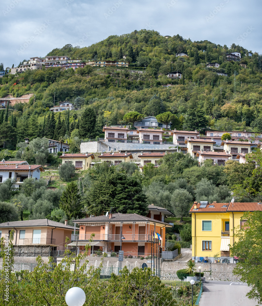 View on an apartment complex on a green hill above Terrazza del Brivido viewpoint. Garda Lake. Italy