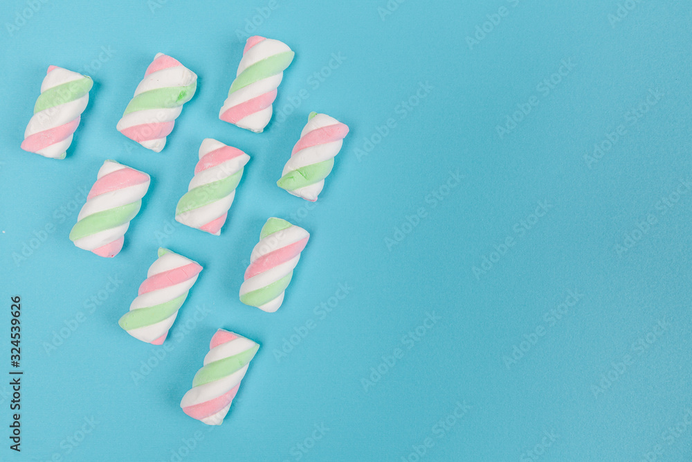 Marshmallows in pastel colors arranged diagonally on light blue background with copy space Marshmallows in pastel colors arranged diagonally on light blue background with copy space