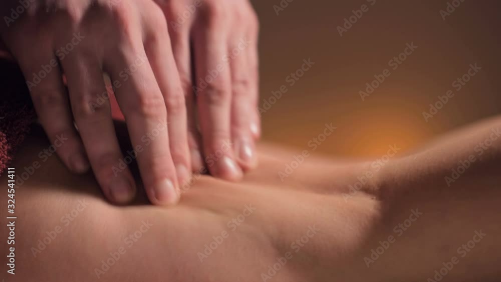 Close-up of premium anti-cellulite thigh massage. Male hands do wellness massage of the thigh to the patient girl in a cozy study with dim light. Luxury massage services Close-up of premium anti-cellulite thigh massage. Male hands do wellness massage of the thigh to the patient girl in a cozy study with dim light. Luxury massage services