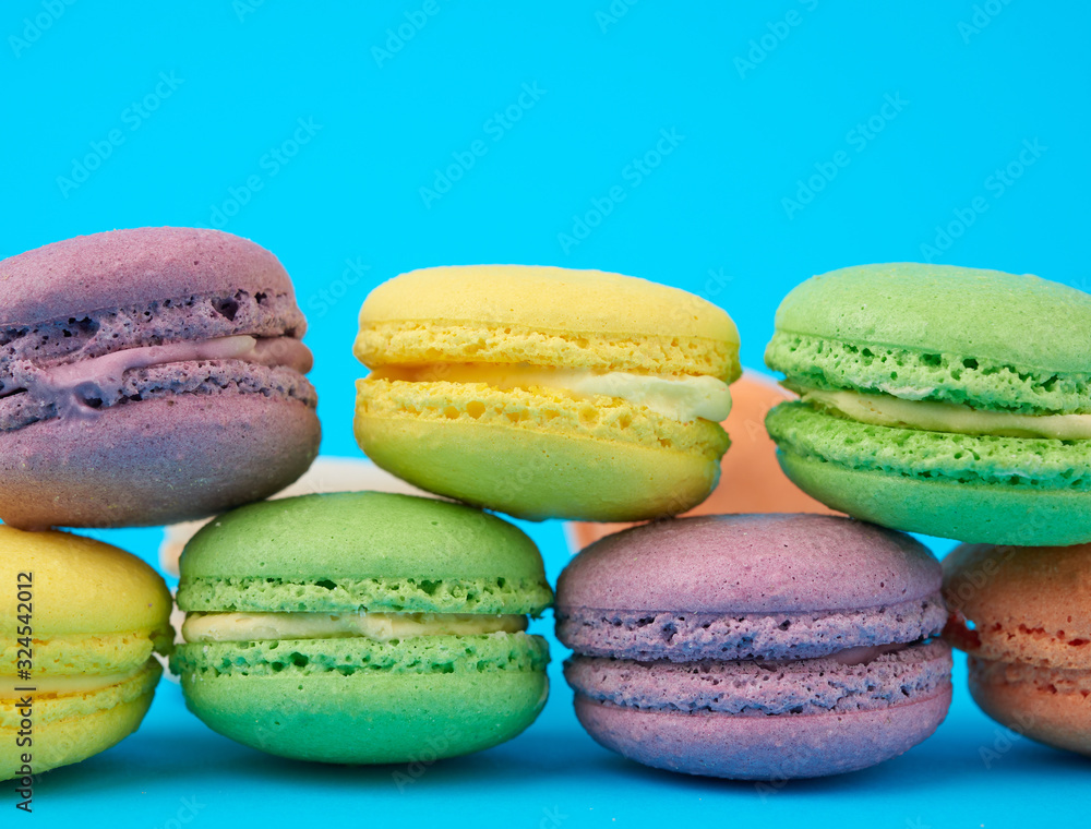 multi-colored round baked macarons cakes on a light blue background multi-colored round baked macarons cakes on a light blue background