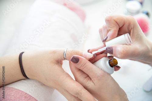 Manicure process in beauty salon - woman hand nails care.