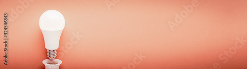 Φωτογραφία LED lamp inverted from a cartridge on a red background with copy space web banne