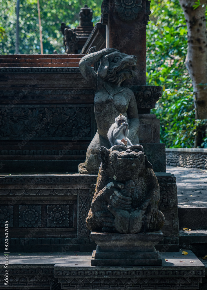 macaque monkey sitting on statue in the park