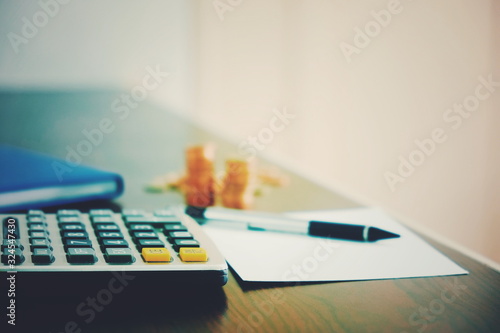 finance business background with calculator pen money and paperwork on desk for accounting and analyzing investment at office work space. banking , savings , accountant , finances and economy concept.