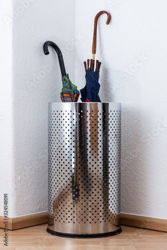Regenschirmständer aus silberfarbenden Metall mit zwei Schirmen