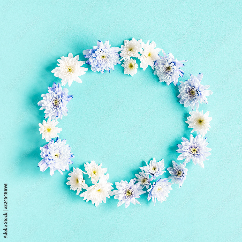 Flowers composition. Wreath made of chrysanthemum flowers on blue background. Flat lay, top view, copy space Flowers composition. Wreath made of chrysanthemum flowers on blue background. Flat lay, top view, copy space