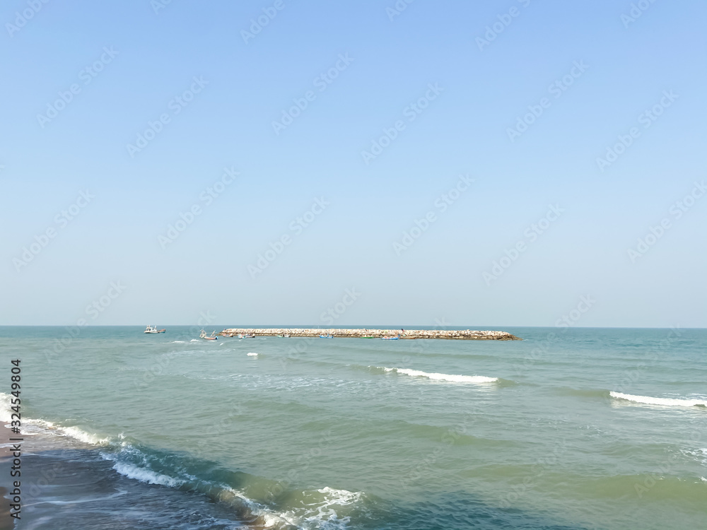 View of waves barrier in the sea with ocean waves against clear blue sky with copy space. View of waves barrier in the sea with ocean waves against clear blue sky with copy space.