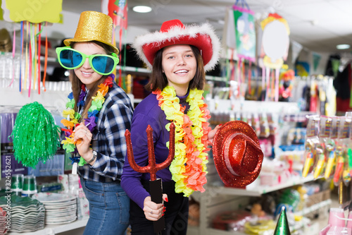 Happy comically dressed female friends  in celebration outfits store