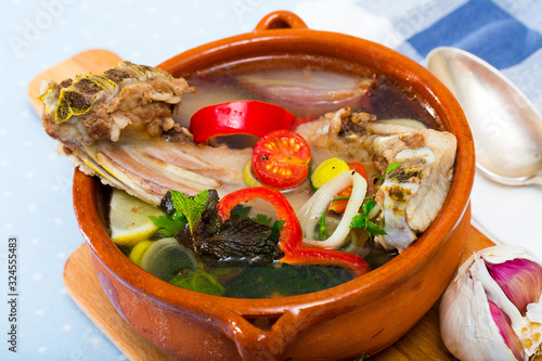 Soup of lamb with vegetables, lemon, onion and greens, served in bowl photo