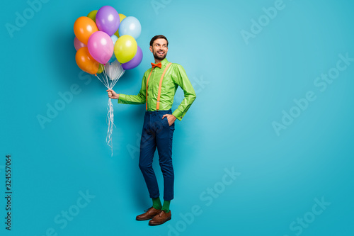 Full length body size view of nice attractive confident cheerful guy holding in hands carrying delivering air balls isolated on bright vivid shine vibrant blue green teal turquoise color background © deagreez