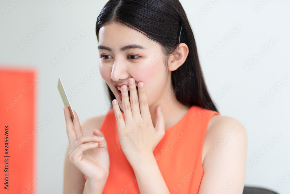 Picture showing smart attractive young asian girl holding credit card with happiness and joyful. Online shopping payment and e-commerce concept. Picture showing smart attractive young asian girl holding credit card with happiness and joyful. Online shopping payment and e-commerce concept.