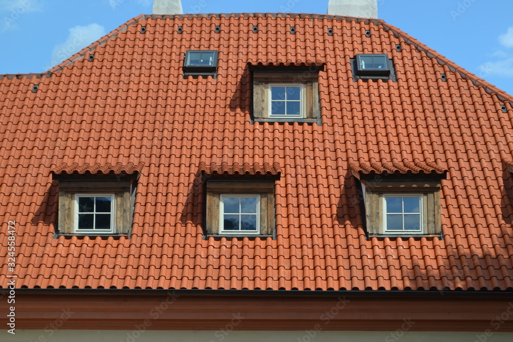 Red roof from roof tiles with roof windows.