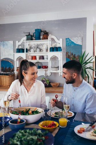 family sits at the dining table and having dinner party at home.